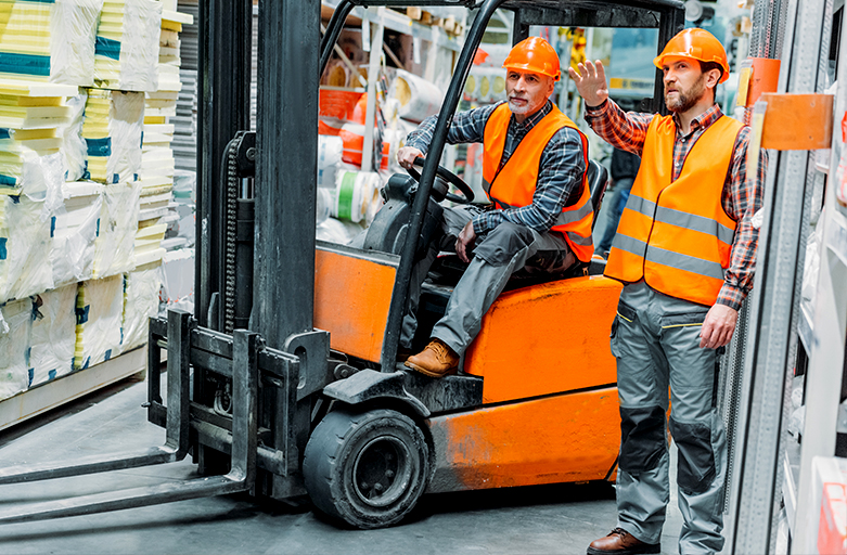 Two men working in a warehouse with forklifts